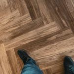 Foot Of Man Wearing Shoes On Wood Flooring - Laminate Flooring Solutions - Woodland Lifestyle